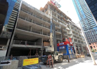 narrow street shot of dual construction hoists at 55 Mercer in Toronto